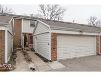 Charming townhouse exterior with a two-car garage, brick accents, and a well-maintained walkway at 351 Carmelaire Ct, Carmel, IN 46032