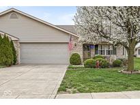 Charming single-story home features a well-manicured lawn, mature flowering tree, and a two-car attached garage at 4038 Oak Trail Dr, Indianapolis, IN 46237