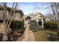 Charming home featuring stone accents, unique architectural design, and well-manicured landscaping at 5400 W Deer Run Ct, Muncie, IN 47304