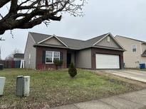 Charming single-Gathering home with a well-manicured lawn, brick accents, and an attached two-car garage at 655 Winding Grove Dr, Indianapolis, IN 46217