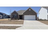 Charming brick home with a well-manicured lawn and a two-car attached garage on a sunny day at 673 Ballycastle Ct, Pendleton, IN 46064