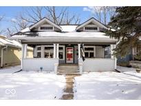 Charming two-story home with a covered front porch, gray siding, and a red front door at 737 N Riley Ave, Indianapolis, IN 46201