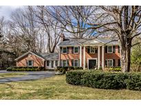Classic brick home featuring a symmetrical facade, grand pillars, and well-manicured landscaping at 8122 Oakland Rd, Indianapolis, IN 46240