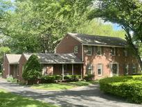 Charming two-story brick home with mature trees, landscaped yard, and covered porch at 925 Forest Dr, Anderson, IN 46011