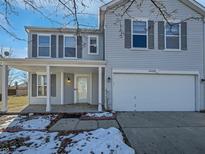 Charming two-story home featuring a welcoming front porch and a two car attached garage at 14466 Bramkrist Dr, Fishers, IN 46038
