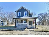 Charming two-story home with a covered front porch and neat landscaping at 2221 Carrollton Ave, Indianapolis, IN 46205