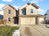 Attractive two-story home with brick and vinyl siding and a three car garage at 4655 Plowman Dr, Indianapolis, IN 46237