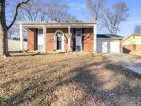 Charming brick home featuring a bright, covered entrance and a well-kept lawn under a clear blue sky at 6130 Midway Ct, Indianapolis, IN 46224