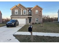 Two-story home with a combination of gray siding and brick, plus an attached two-car garage and a modern, black SUV parked in the driveway at 10317 Caprock Canyon Dr, Indianapolis, IN 46229