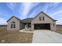 New construction single-Gathering home with gray brick, large garage and driveway under a blue sky at 10502 Oak Bend Blvd, Indianapolis, IN 46239