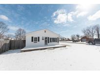 Cozy single-story home featuring a charming entrance, set against a bright blue sky and snow-covered yard at 111 Wehmeier St, Columbus, IN 47201