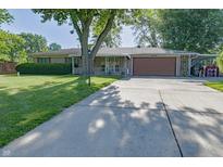 Charming ranch-style home with a long driveway and well-maintained lawn at 1231 S Catherwood Ave, Indianapolis, IN 46203