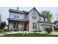 Charming two-story home featuring a brick facade, gray siding, attached garage, and well-manicured front lawn at 1501 Willshire Dr, Greenwood, IN 46143