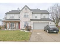 Charming two-story home with a well-manicured lawn, gray siding and brick accents and attached two car garage at 1501 Willshire Dr, Greenwood, IN 46143
