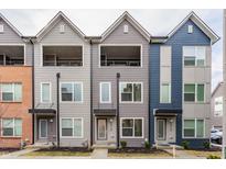 Modern townhome featuring varied neutral siding and individual entryways with small patios at 2115 Coretta Way, Indianapolis, IN 46202