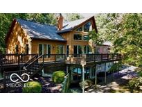 Stunning multi-story home featuring a large deck and surrounded by mature trees at 3932 W Poplar Point Ct, Trafalgar, IN 46181