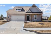 Charming, single-story home with a gray brick facade, attached garage, and well-manicured lawn at 5040 Carmine St, Brownsburg, IN 46112