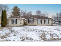 Charming single-story home with a brick exterior and neatly trimmed evergreens at 517 King Arthur Dr, Franklin, IN 46131