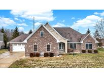 Charming brick home featuring manicured landscaping and an attached two car garage at 6014 Easy Ln, Indianapolis, IN 46259