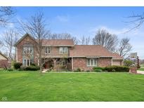 Charming two-story brick home with a spacious front yard and mature trees at 7018 W Anton Way, New Palestine, IN 46163