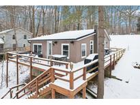 Charming home featuring a large deck with outdoor seating and a grill, perfect for entertaining in a snowy, wooded setting at 8159 S Fox Ln, , IN 46164
