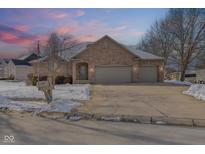 Charming brick home featuring a two-car garage and a well-maintained front yard at 11 Stratford Way, Danville, IN 46122