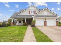 Charming home with a well-manicured lawn, attached two-car garage, and inviting front porch at 11130 Sanabria Dr, Indianapolis, IN 46235