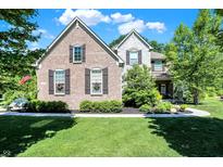 Charming brick and stone home with manicured lawn and flower-filled window boxes at 11226 Aviemore Ct, Zionsville, IN 46077