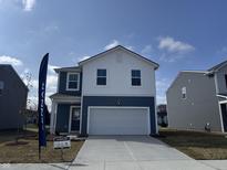 Charming two-story home boasts a contemporary design with white and blue siding and an attached two-car garage at 11711 Cotterill Way, Indianapolis, IN 46235