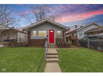 Charming single-Gathering home with a well-maintained front lawn and inviting red front door at 1421 Shepard St, Indianapolis, IN 46221