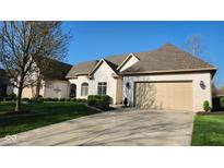 Beautiful white brick home with a manicured lawn and driveway leading to a beige garage at 1655 Rosebud Ln, Greenwood, IN 46143