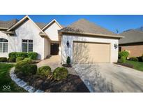 Charming white brick home with a well-manicured lawn and a beige garage door on a sunny day at 1655 Rosebud Ln, Greenwood, IN 46143