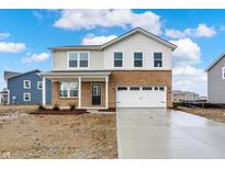 Inviting two-story home featuring a brick and vinyl facade, attached two-car garage, and a freshly poured concrete driveway at 2004 Foothill Dr, Greenfield, IN 46140