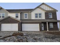 New two-story townhome showcases a brick facade, attached two-car garage, and bright, white-trimmed windows at 2996 Grand Ridge Dr, Greenwood, IN 46143