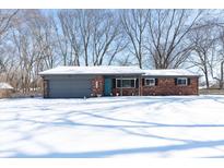 Charming single-story brick home with a well-maintained front yard covered in snow on a sunny winter day at 3549 Woodale Rd, Indianapolis, IN 46234