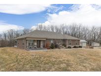 A brick home with a covered porch and a beautiful waterfall feature in the front yard at 3764 S 475 W, Trafalgar, IN 46181