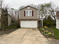 Charming two-story home with a two-car garage and a cozy front garden showcasing colorful flowers at 6534 Redland Way, Indianapolis, IN 46217
