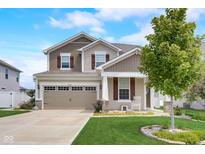 Charming two-story home featuring a well-maintained lawn and a welcoming front porch with a traditional two car garage at 6648 Harvest Moon Ln, Whitestown, IN 46075