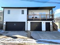 Modern two-story home with white siding, black trim, balcony, and a two-car garage with an Airbnb logo at 1046 Nelson Ave, Indianapolis, IN 46203