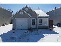 A charming single-story home boasts a one-car garage and a cozy front yard covered in fresh snow at 10885 Walnut Grove Bnd, Camby, IN 46113