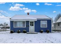 Charming blue home featuring a snow-covered yard, classic design, and inviting entrance at 1651 Lawton Ave, Indianapolis, IN 46203