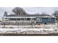 Charming single story home with a fenced yard, covered front porch, and snowy winter scenery at 2758 S Lyons Ave, Indianapolis, IN 46241