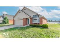 Charming brick home with attached garage, green lawn and bay window, showcasing suburban living at 2979 Colony Lake E Dr, Plainfield, IN 46168