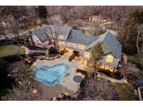 Aerial view of the home at dusk with in-ground pool, patio, and a beautifully landscaped lot at 3803 Nesbitt Rd, Indianapolis, IN 46220