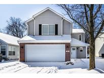 Charming two-story home featuring a two-car garage, red brick accents and snow covered yard at 41 White Lick Dr, Indianapolis, IN 46227