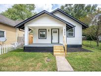Charming home features a manicured lawn and inviting porch, with black and white trim at 509 St Paul St, Indianapolis, IN 46203