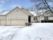 Charming single Gathering home with a brick exterior, attached garages and snow covered front yard at 5791 Station Hill Dr, Avon, IN 46123