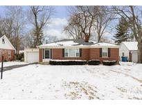Charming brick ranch home featuring an attached garage and a well-maintained front yard at 5838 Brouse Ave, Indianapolis, IN 46220