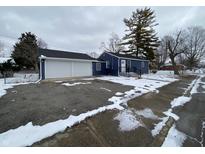 Charming blue home with a two-car garage and front porch at 6018 Ivanhoe St, Indianapolis, IN 46219