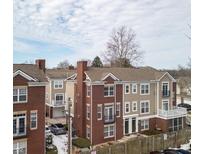 Beautiful exterior showcasing brick and tan siding with decorative balconies on a partly cloudy day at 65 Florence St, Carmel, IN 46032